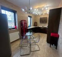 A kitchen in a family house with a wooden decor floor and a glass table.