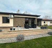 Terrace of a family house in Komárno with flower pots and outdoor seating.