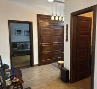 A hallway in a family house with a wooden decor floor and wooden doors.