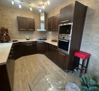 A kitchen in a family house with wooden floor decor and abundant lighting.