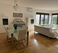 Living room in a family house with wood-patterned flooring and white furniture.