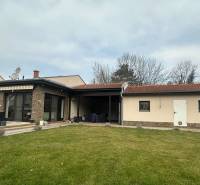 A family house in Komárno with a terrace, stone cladding, and a satellite dish on the roof.