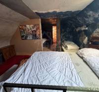 Attic bedroom in a family house with a painting and a blue wall full of patterns.