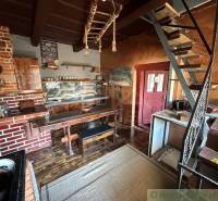 A kitchen in a family house with brick elements and a wooden decor floor.