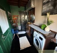 A bathroom in a family house with a wooden decor floor, washing machine, mirror, decorations.