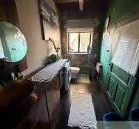 A bathroom in a family house with dark walls, a toilet, and a washing machine.