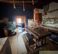 Rustic kitchen in a family house with a wooden table and brick detail.