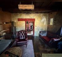 Rustic living room in a family house with leather armchairs and a wooden decor floor.