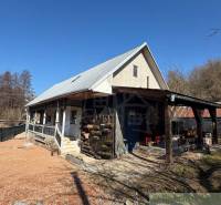 A family house in Ratkovské Bystré with a gable roof and a wooden veranda.
