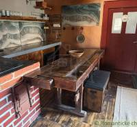 Rustic kitchen in a family house with brick details and a wooden decor floor.