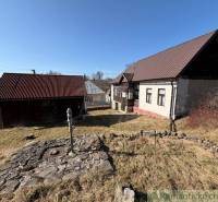 A family house in Lipovec with a stone well and a wooden annex in the yard.
