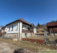 A family house in Lipovec surrounded by grass and a fence under a blue sky.