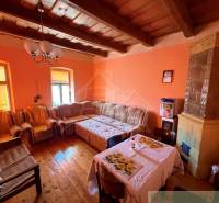 A living room in a family house with a tiled stove and a floor with a wooden decor.