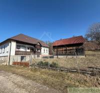 A family house in Lipovec with an adjacent building, fenced plot, clear sky.