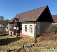 A family house in Lipovec with a brown roof and a veranda, surrounded by a grassy plot.