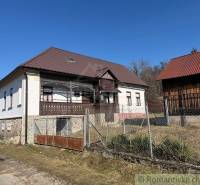 A family house in Lipovec with a stone foundation, wooden details, and a metal roof.
