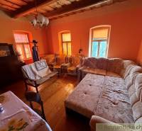 Living room in a family house with a large couch and a wooden decor floor.