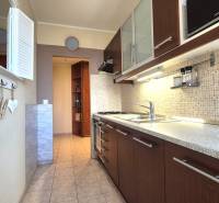 A kitchen with tiles and a countertop in a 2-room apartment, equipped with a gas stove.