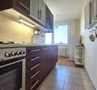 Kitchen in a 2-room apartment with a stove, wooden decor, light decoration, window with radiator.