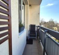 The balcony of a 2-room apartment on Bratislavská Street in Piešťany with comfortable seating and plants.