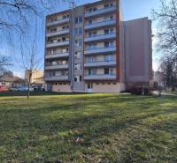 An apartment building on Bratislavská Street in Piešťany surrounded by greenery and trees.