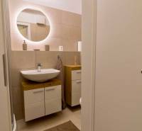 Bathroom with a sink and a mirror, part of a studio apartment.