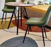 Interior of a 1-room apartment with a colorful carpet, table, and green chairs, floor with decor.