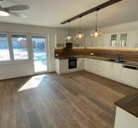 A kitchen in a family house with wooden floor decor and modern lighting.