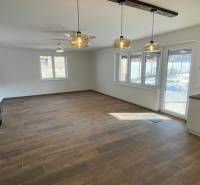 Spacious living area with wood-patterned flooring in a family house.