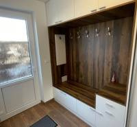 A wardrobe with hangers and cabinets, a floor with a wood decor. Family house.