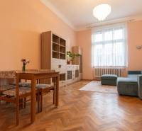 Living room with a sofa, table, and wooden decor flooring in a 3-room apartment.