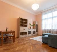 Living room in a 3-room apartment with a wooden decor floor, sofa, and furniture.