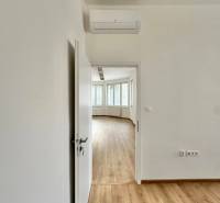 The doors lead to an office with a wooden decor floor and air conditioning.