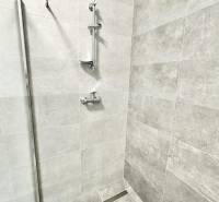 A shower corner with modern tiles and stainless steel accessories in the office.