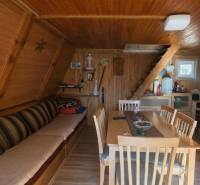 Interior of a cabin with wooden paneling, stairs, and a floor with a wooden decor.