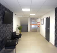 Hallway in a 3-room apartment with a TV on the wall and an elevator in the background.