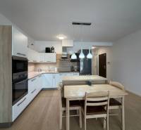 A kitchen in a 3-room apartment with a wooden decor floor and a dining table.