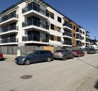New apartment buildings on Topoľčianska Street in Košice, Západ district, with cars parked in front.
