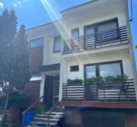 A family house on Tálová Street in Veľké Orvište with two balconies, trees, and a garage.