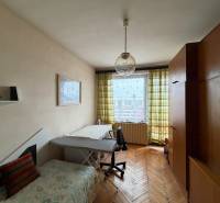 A room in a family house with a wooden decor floor, a couch, and a large wardrobe.