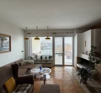 Living room in a family house with a fireplace, sofa, and wooden decor flooring.