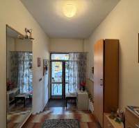 Entrance hall in a family house with tiles, a mirror, and decorative lighting.