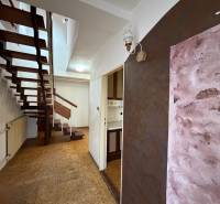 A hallway with open stairs in a family house, floor with wooden decor.