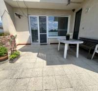 The terrace of a family house on Tálová Street in Veľké Orvište with a plastic table and flowers.