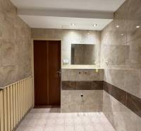 A bathroom in a family house with tiles, a mirror, and a radiator.