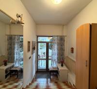 Interior of a family house with a mirror, wardrobe, tiles, and a view of the garden.