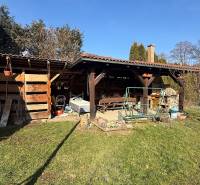 The garden of a family house in Lutila, with a wooden shelter and a swing on the property.