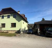 A family house in Lutila with two cars parked in front of the garage on a paved driveway.