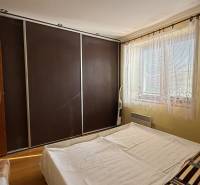 Bedroom interior in a family house with a large built-in wardrobe and a bed.