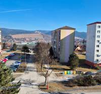 Housing estate in Stará Ľubovňa with a parking lot and a view of the hills.